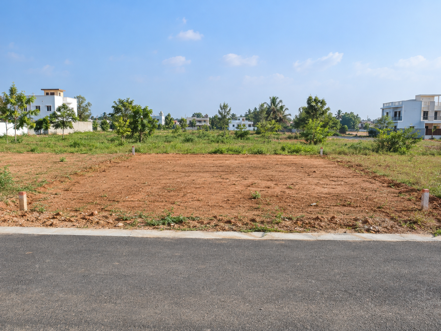 Illustrative sample photo of a vacant residential plot beside a road